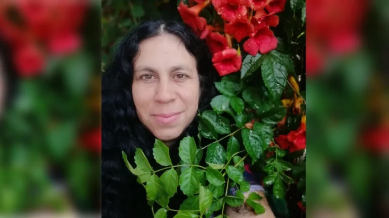 Cintia Ceballos sentada en el patio de su casa con un mate y una sonrisa