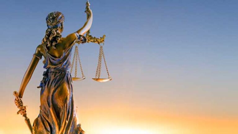 Símbolo de la justicia sobre libros de leyes, representando la ética judicial.