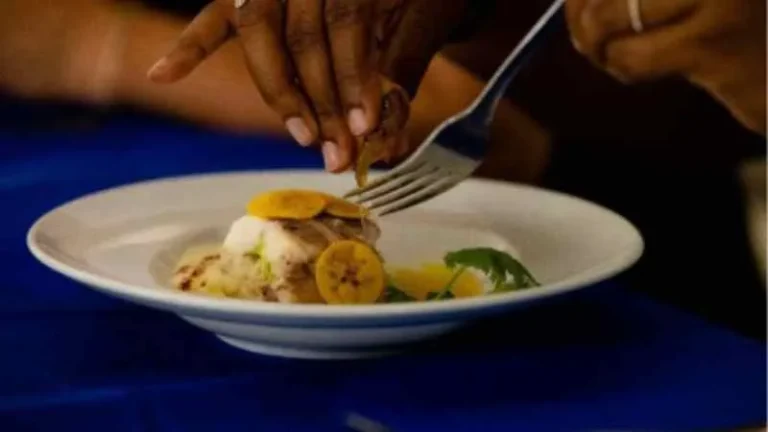 Chefs preparando platos durante un festival gastronómico en una playa del Caribe.