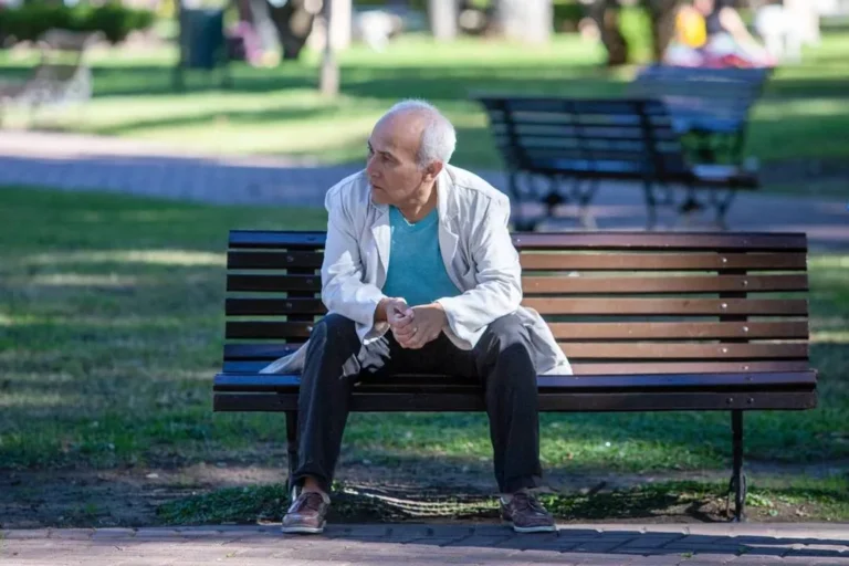 Persona mayor sosteniendo billetes de 1000 pesos argentinos