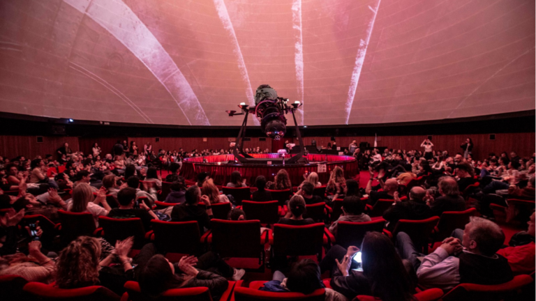 Interior de la cúpula del Planetario de Rosario con proyecciones digitales de la Luna y efectos de luz.