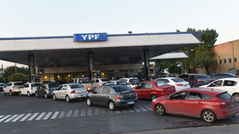 Estación de servicio en Rosario con surtidor de combustible y precios visibles.