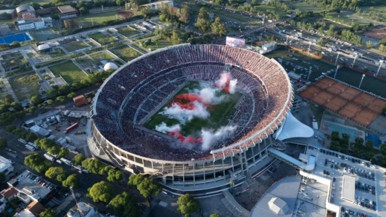 Libros sobre fútbol y las hinchadas de River Plate y Boca Juniors sobre una bandera argentina.