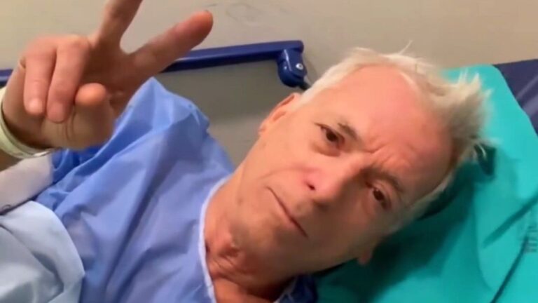 Gerardo Romano en camilla de hospital con vía intravenosa y bata quirúrgica