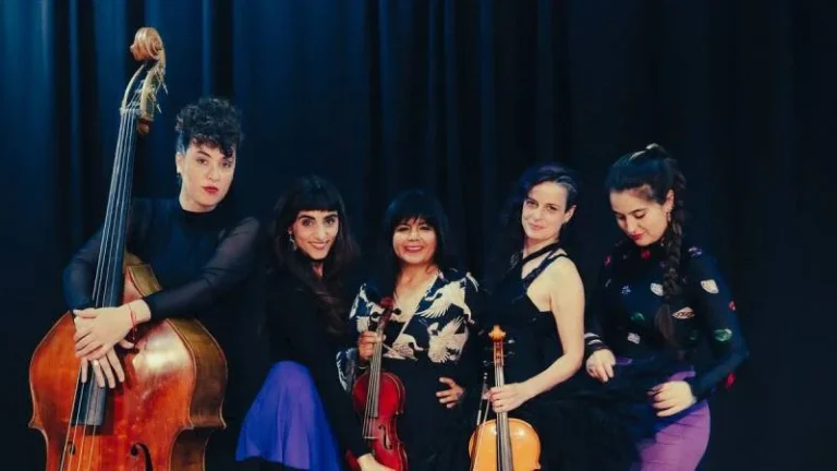 Integrantes de la Orquesta de Señoritas en escena con instrumentos musicales
