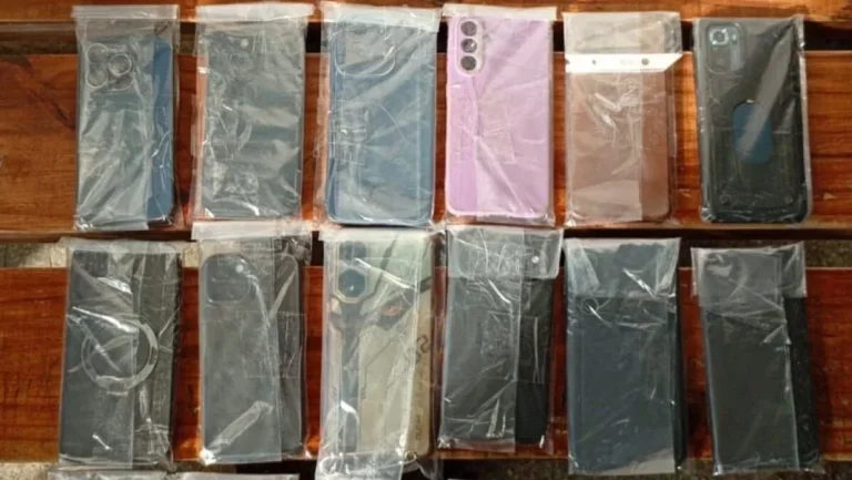 Efectivos policiales revisan teléfonos celulares recuperados durante un operativo en Rosario