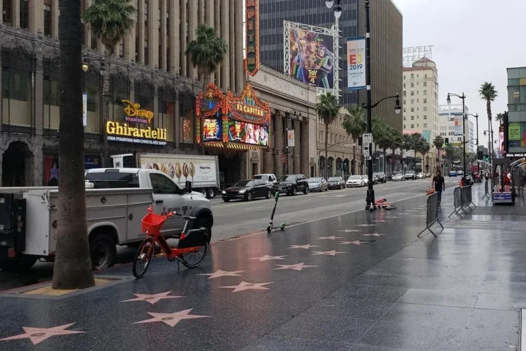 Vista del Paseo de la Fama de Hollywood con estrellas en el suelo y edificios al fondo