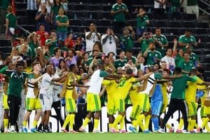 Estadio de fútbol con banderas de países anfitriones del Mundial 2026