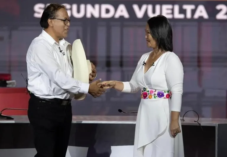 Urnas electorales y bandera de Perú en un centro de votación